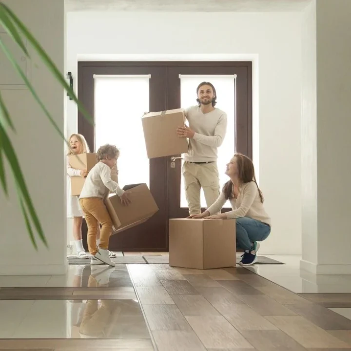 A group of people in the house with boxes.